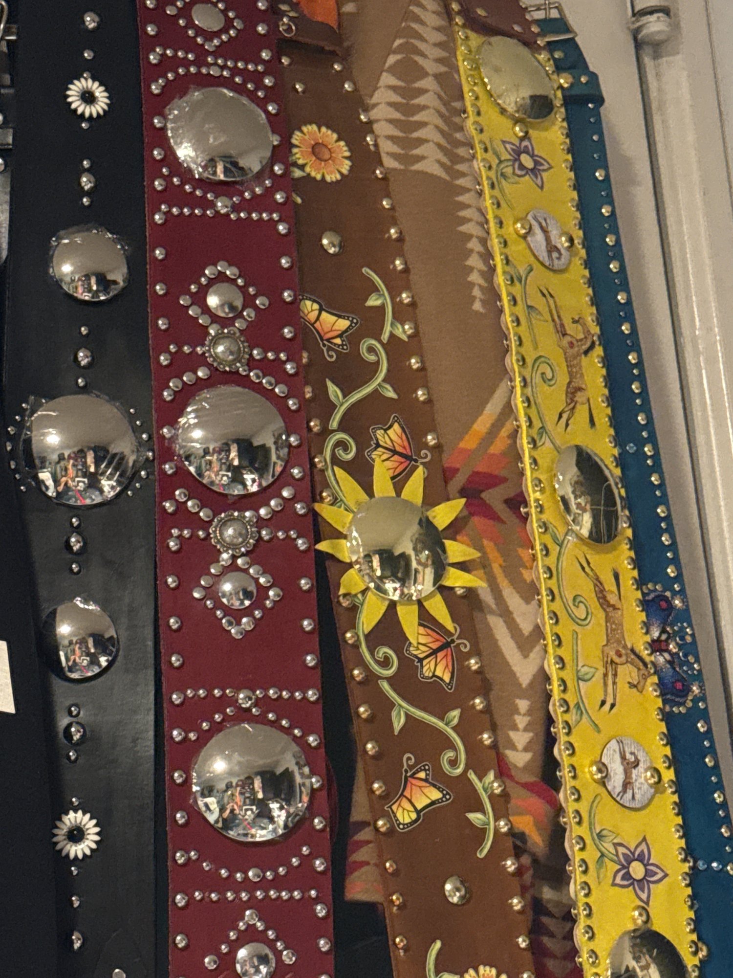 Handmade DawnStar leather belts in teal, yellow, brown, dark red, and black